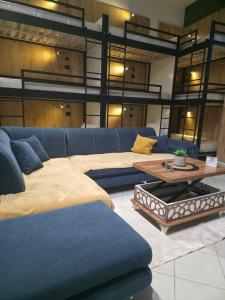 a living room with a blue couch and a table at City Center Hostel Durres in Durrës