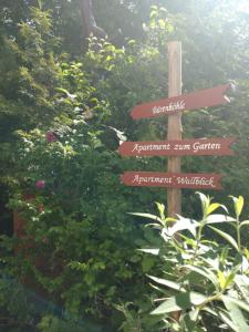 a wooden sign with arrows pointing in different directions at Apartment Wallblick in Nienburg +21 photos