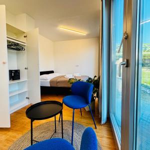a bedroom with a bed and a blue chair and a table at Sundeck botel - party boat in Bratislava +33 photos