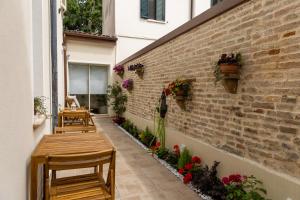 a patio with benches and flowers on a brick wall at Casa GenaRita in Ravenna