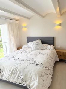 a bedroom with a bed with white sheets and a window at Precioso bungalow con piscina en 1a Linea Playa in Denia +23 photos