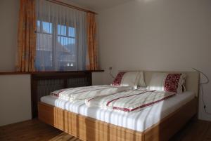 Bett in einem Zimmer mit Fenster in der Unterkunft FeWo Wassertheurer in Tröpolach