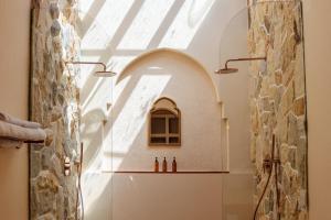 a bathroom with a shower with a stone wall at Miliyana Boutique Hotel - Adults Only in Kuta Lombok +39 photos