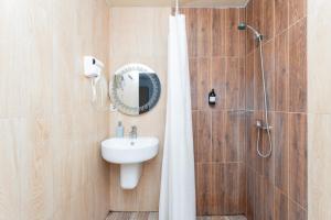 a bathroom with a sink and a shower with a mirror at Alex Hotel in Yerevan +83 photos