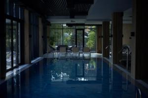 a swimming pool with chairs in a building at GirSki in Bukovel