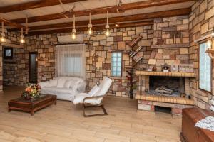 a living room with a stone wall with a fireplace at Emilia's Little Farmhouses in Agii Anargiri Milos