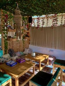 a room with two wooden tables and a couch at Wabi Sabi Hostel in Kasol +13 photos