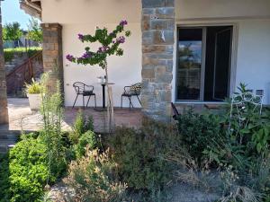 a patio with two chairs and a table with purple flowers at Room Monika in Izola