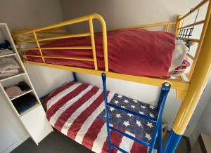 a bunk bed in a room with an american flag blanket at L Escale du Lioran in Le Lioran