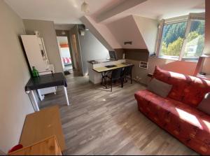 a living room with a red couch and a table at L Escale du Lioran in Le Lioran