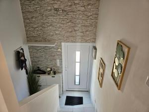 a stairway with a brick wall and a white door at Modernes Haus nahe See mit Garten & Terrasse in Velm