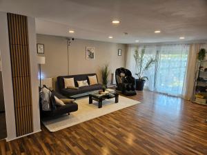 a living room with a couch and a table at Modernes Haus nahe See mit Garten & Terrasse in Velm