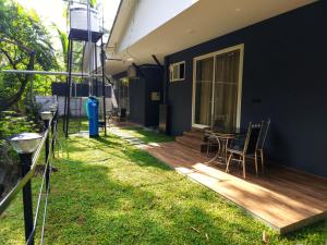 a deck with a table and chairs on a house at Creek Cottage in Kollam