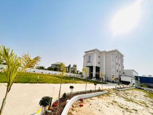 a large white building with palm trees in front of it at The RK Resort in Siwān