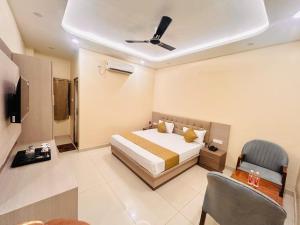 a bedroom with a bed and a tv and a chair at The RK Resort in Siwān