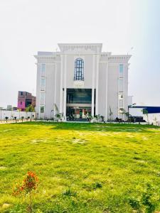 a large building with a grass field in front of it at The RK Resort in Siwān