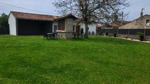 a green yard with chairs and a house at Casa soengas in Monterroso