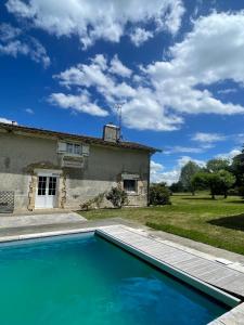 a villa with a swimming pool in front of a house at Du coté de chez Flo in Bazas
