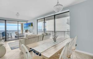 a dining room with a table and a couch at Corner on Romar 706 in Orange Beach
