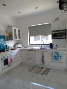 a kitchen with white cabinets and a sink and a window at Tulip Apartment in Cambridge