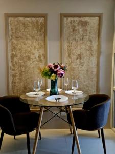 a table with chairs and a vase of flowers on it at Alder Wind Staycations Tagaytay in Kaybagal