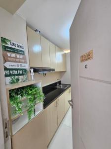 a kitchen with a sink and a counter with plants at Alder Wind Staycations Tagaytay in Kaybagal