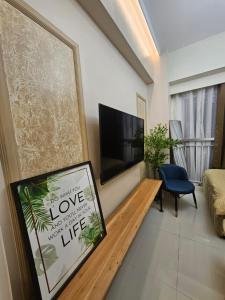 a living room with a flat screen tv on a wall at Alder Wind Staycations Tagaytay in Kaybagal
