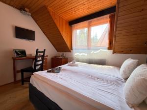 a bedroom with a large white bed with a window at Red Lake Inn in Gheorgheni