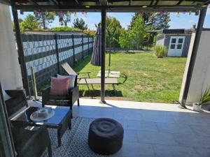 a patio with an umbrella and a chair and a table at Modernes Haus nahe See mit Garten & Terrasse in Velm