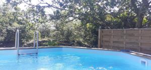 ein Swimmingpool in einem Hinterhof mit einem Zaun und Bäumen in der Unterkunft Studio 315 in Villeneuve-de-Berg