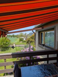 a balcony with a view of a field and a window at Your home in Gohrisch in Kurort Gohrisch