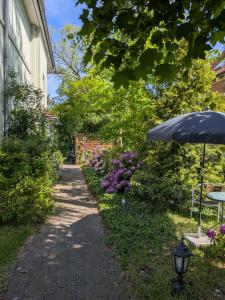 a walkway leading to a house with an umbrella at Pension Celia in Wismar +69 photos