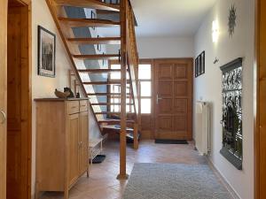 a hallway with a wooden staircase in a house at Ferienhaus Engel in Fertőhomok