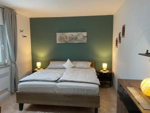 a bedroom with a bed with a green wall at Ferienhaus Engel in Fertőhomok +38 photos