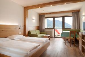 a hotel room with two beds and a table and chairs at Hotel Appartement Inge in Tirolo +106 photos