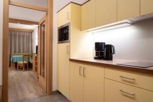 a kitchen with white cabinets and a dining room at Hotel Appartement Inge in Tirolo