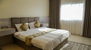 a bedroom with a large bed with a large window at Al Sahwa Residency in Ţāqah +18 photos