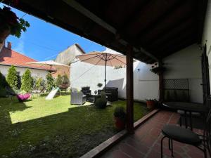 a patio with an umbrella in a yard at Stari grad 1 in Valjevo