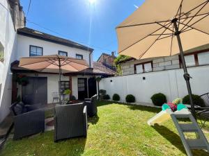 a yard with an umbrella and chairs and a house at Stari grad 1 in Valjevo