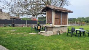 a wooden building with tables and chairs in a yard at Casa soengas in Monterroso