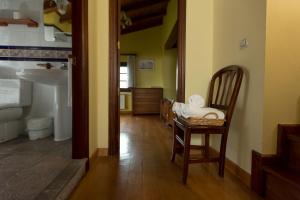 ein Badezimmer mit Stuhl, Waschbecken und Toilette in der Unterkunft Casas Rurales Playa de Guadamía in Llames de Pría + 34 Fotos