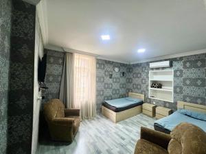a bedroom with a bed and a couch and a chair at Ruslan Hotel 1 in Poti