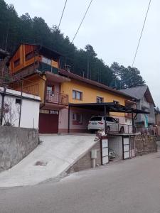 a house with a car parked in front of it at Apartments AZRA in Konjic