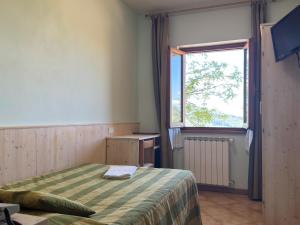 a small bedroom with a bed and a window at Hotel Da Giovanna in Chiusi della Verna