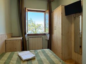a bedroom with a bed and a window and a television at Hotel Da Giovanna in Chiusi della Verna +39 photos