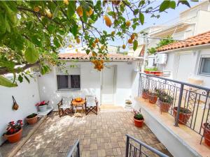 a patio of a house with a table and chairs at Al Mar in Skiathos