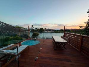 a deck with a pool and a table and a bench at Pet Friendly - Plunge Pool Canal Sunset View - Private Jetty in Bongaree