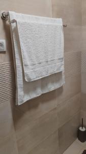 a bathroom with white towels hanging on a wall at Bella Lux Centar in Mladenovac +25 photos