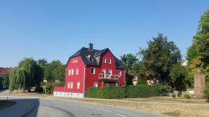 a large red house on the side of a road at Ferienapartment Meiss in Erdeborn