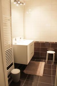 a bathroom with a sink and a toilet and a stool at Le Clos Saint Morand in Balschwiller